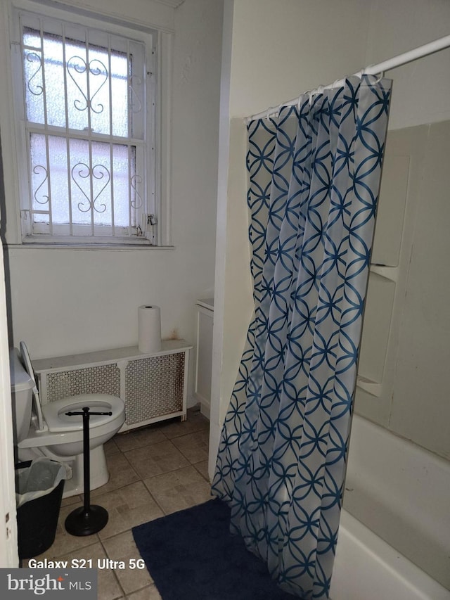 bathroom featuring tile patterned floors, radiator heating unit, toilet, and shower / tub combo