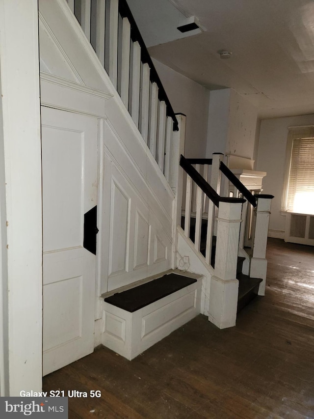 stairs with radiator and hardwood / wood-style flooring