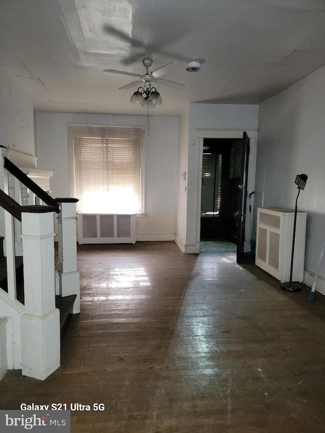 interior space featuring ceiling fan, radiator heating unit, and dark hardwood / wood-style flooring