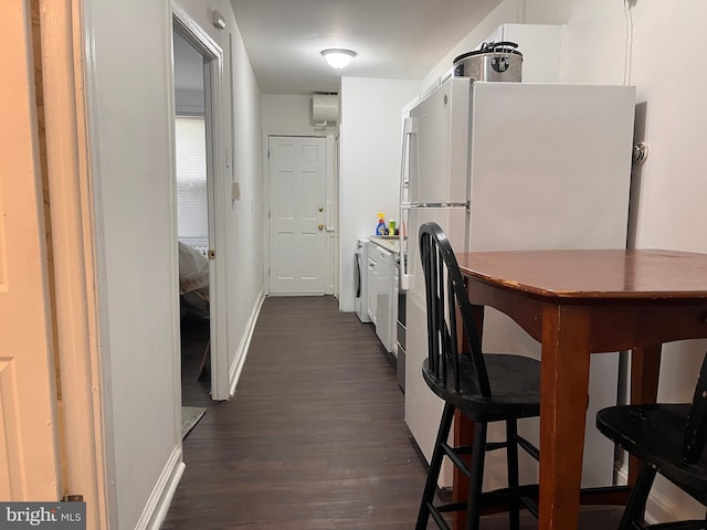 kitchen featuring white refrigerator, white cabinetry, washer / dryer, and dark hardwood / wood-style floors