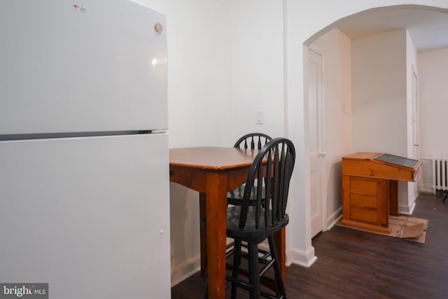 dining space with radiator and dark hardwood / wood-style floors