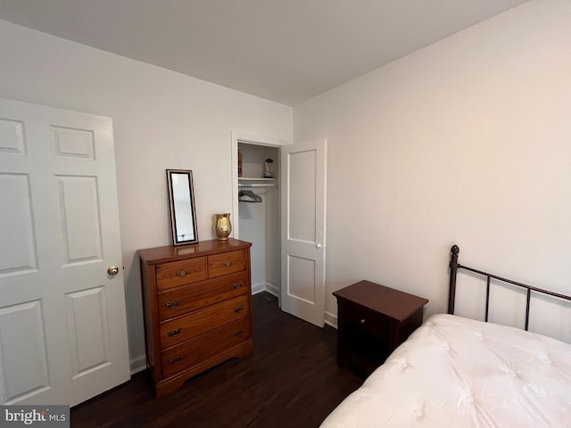 bedroom with dark wood-type flooring and a closet