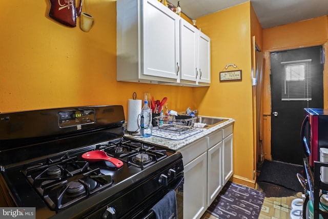 kitchen featuring white cabinets and black gas range oven