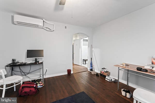 office area featuring hardwood / wood-style flooring, ceiling fan, and a wall unit AC