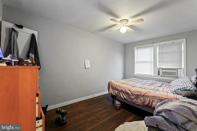 bedroom featuring cooling unit, dark hardwood / wood-style floors, and ceiling fan