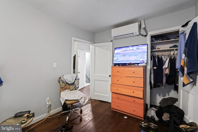 spacious closet featuring a wall mounted air conditioner and dark hardwood / wood-style floors