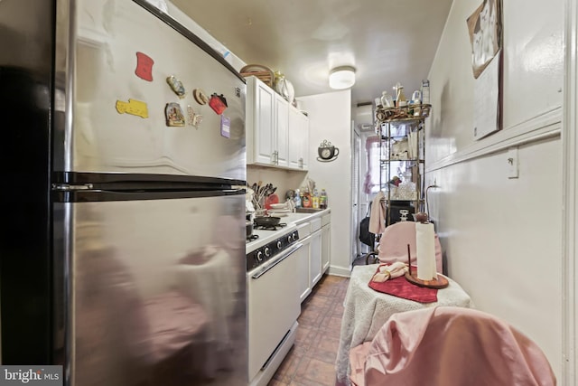 kitchen with white cabinets, white range, and stainless steel fridge