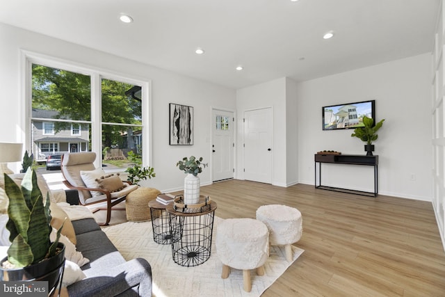 living area featuring recessed lighting, baseboards, and light wood finished floors