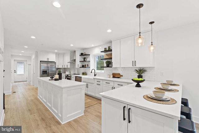 kitchen featuring stainless steel appliances, open shelves, light countertops, and white cabinetry