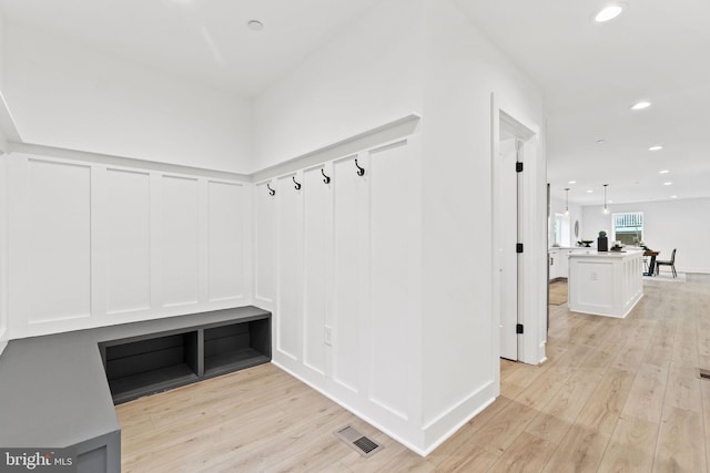 mudroom featuring light wood finished floors, visible vents, and recessed lighting