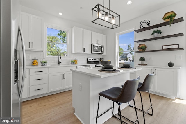 kitchen featuring open shelves, appliances with stainless steel finishes, and white cabinetry