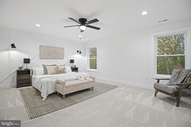 bedroom featuring light colored carpet, visible vents, and multiple windows