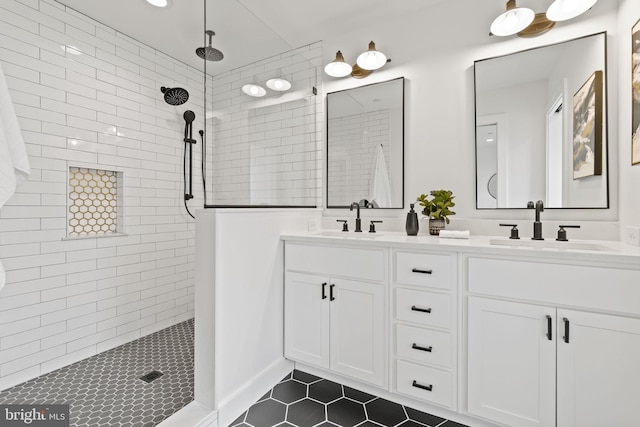 bathroom with double vanity, walk in shower, a sink, and tile patterned floors