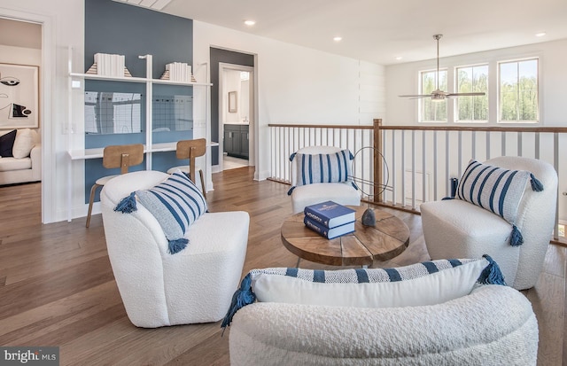 living room featuring wood-type flooring and ceiling fan