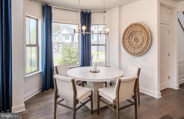 dining space with dark hardwood / wood-style flooring and a chandelier