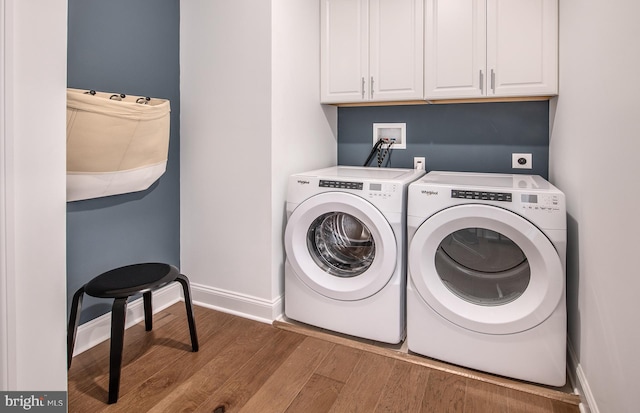 clothes washing area with cabinets, independent washer and dryer, and light hardwood / wood-style flooring