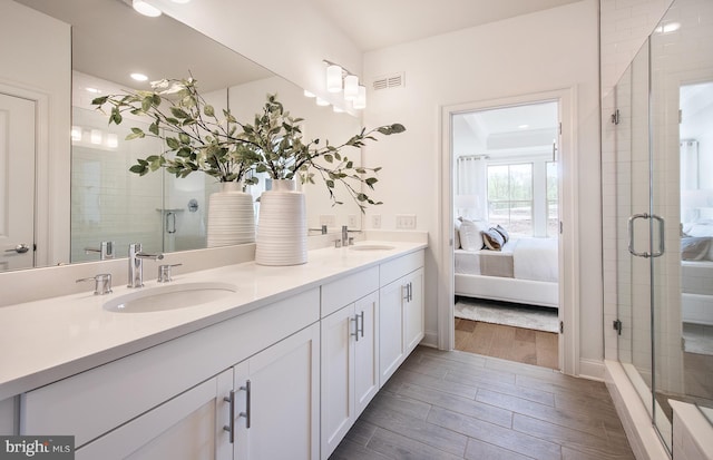 bathroom with a shower with door and vanity