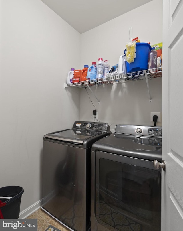 clothes washing area with laundry area, light tile patterned floors, baseboards, and separate washer and dryer