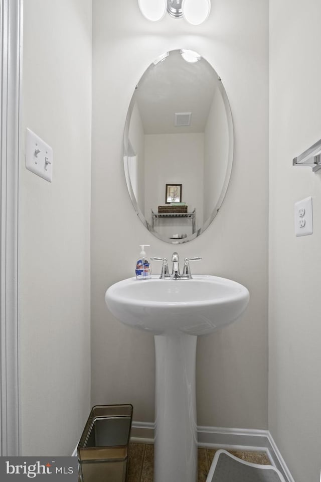 bathroom with tile patterned flooring, visible vents, a sink, and baseboards