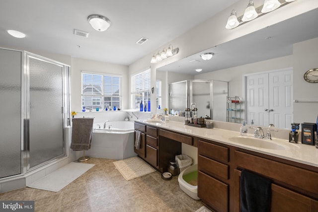 bathroom with a garden tub, a shower stall, visible vents, and a sink