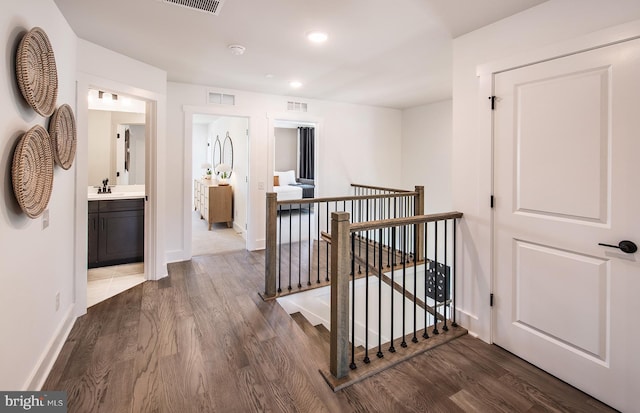 hallway with hardwood / wood-style flooring and sink