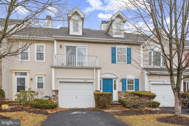 multi unit property featuring a garage and a balcony