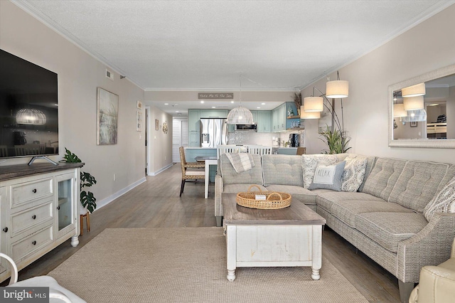 living room with crown molding, wood-type flooring, and a textured ceiling