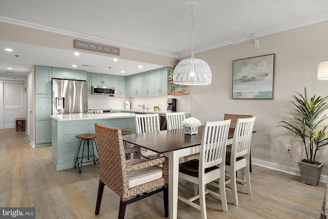 dining room with crown molding, sink, a textured ceiling, and light wood-type flooring