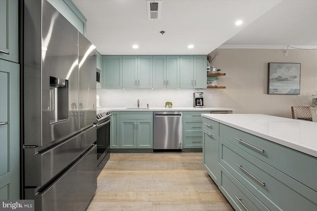 kitchen featuring sink, tasteful backsplash, light stone counters, ornamental molding, and appliances with stainless steel finishes