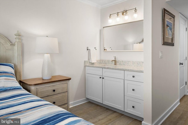 bedroom with crown molding, sink, and dark hardwood / wood-style floors