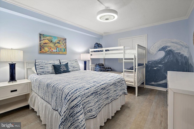 bedroom with crown molding, a textured ceiling, and hardwood / wood-style flooring