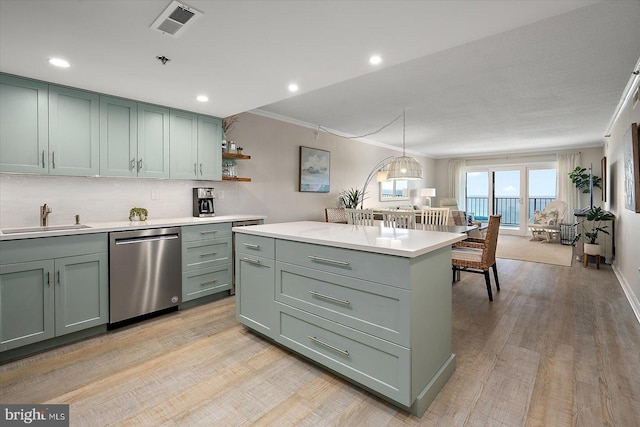 kitchen featuring sink, light wood-type flooring, ornamental molding, dishwasher, and green cabinets