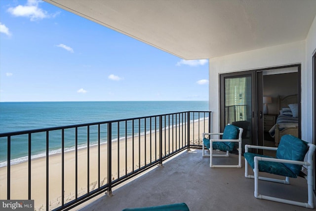 balcony featuring a water view and a beach view