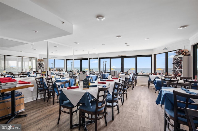 dining space with a water view and hardwood / wood-style floors