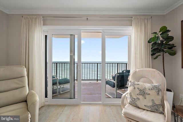 living area featuring a water view, crown molding, and light hardwood / wood-style flooring