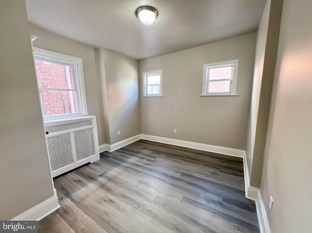 spare room with wood-type flooring and radiator heating unit