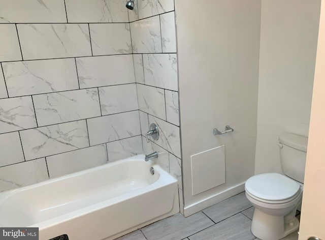 bathroom with tiled shower / bath and toilet