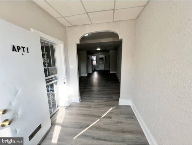 corridor featuring hardwood / wood-style flooring and a paneled ceiling