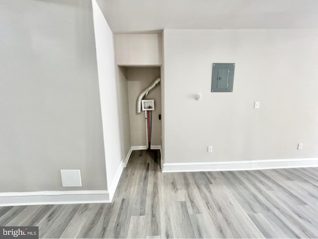 unfurnished room featuring electric panel and light hardwood / wood-style flooring