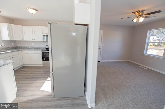 kitchen with white cabinetry, sink, ceiling fan, light hardwood / wood-style floors, and stainless steel appliances