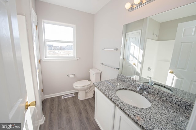 bathroom with vanity, hardwood / wood-style flooring, toilet, and a shower