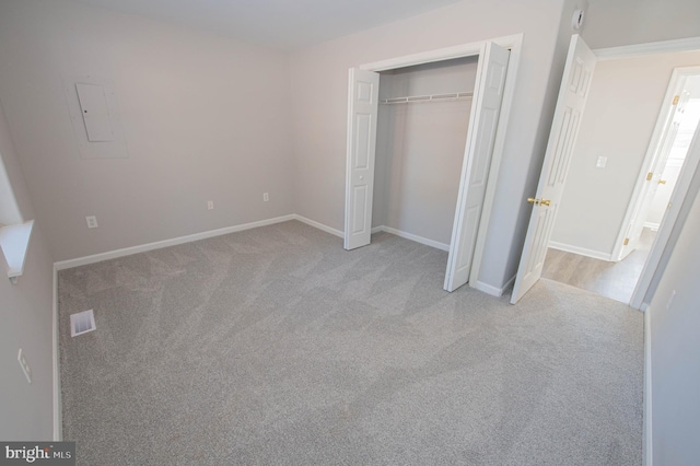 unfurnished bedroom featuring light carpet and a closet