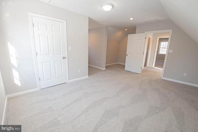 bonus room with vaulted ceiling and light colored carpet