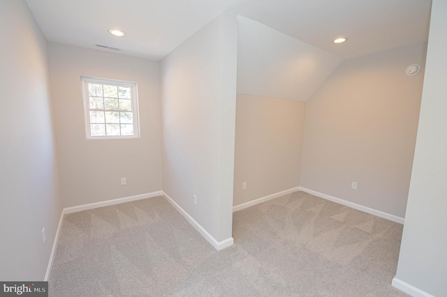 additional living space with vaulted ceiling and light colored carpet