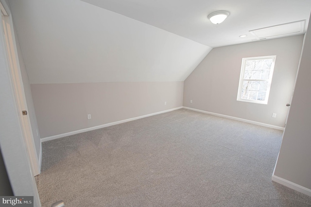 bonus room with lofted ceiling and light colored carpet