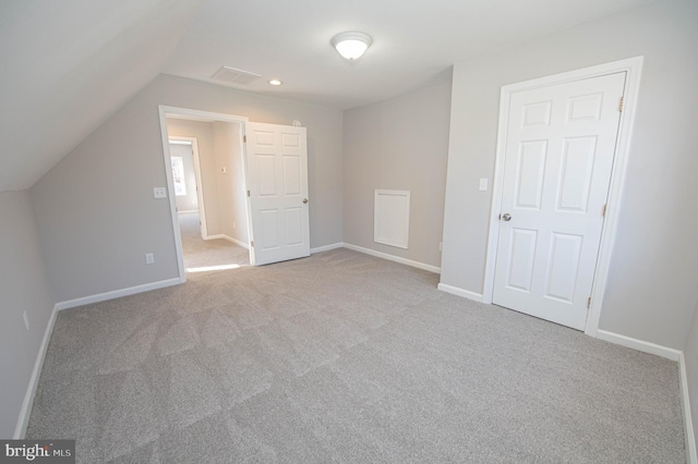 additional living space with lofted ceiling and light carpet