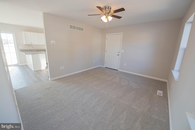 spare room featuring light colored carpet and ceiling fan