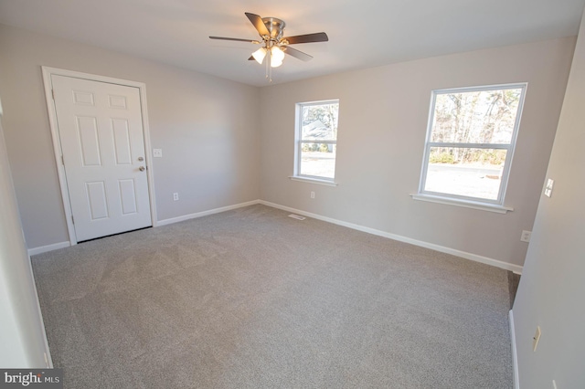 empty room with light colored carpet and ceiling fan