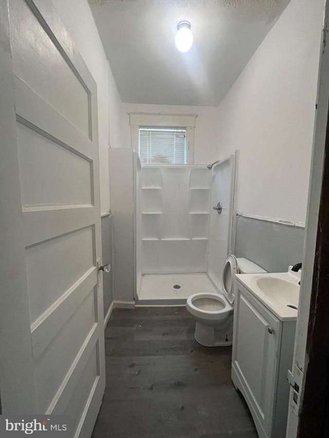 bathroom with walk in shower, vanity, toilet, and hardwood / wood-style floors