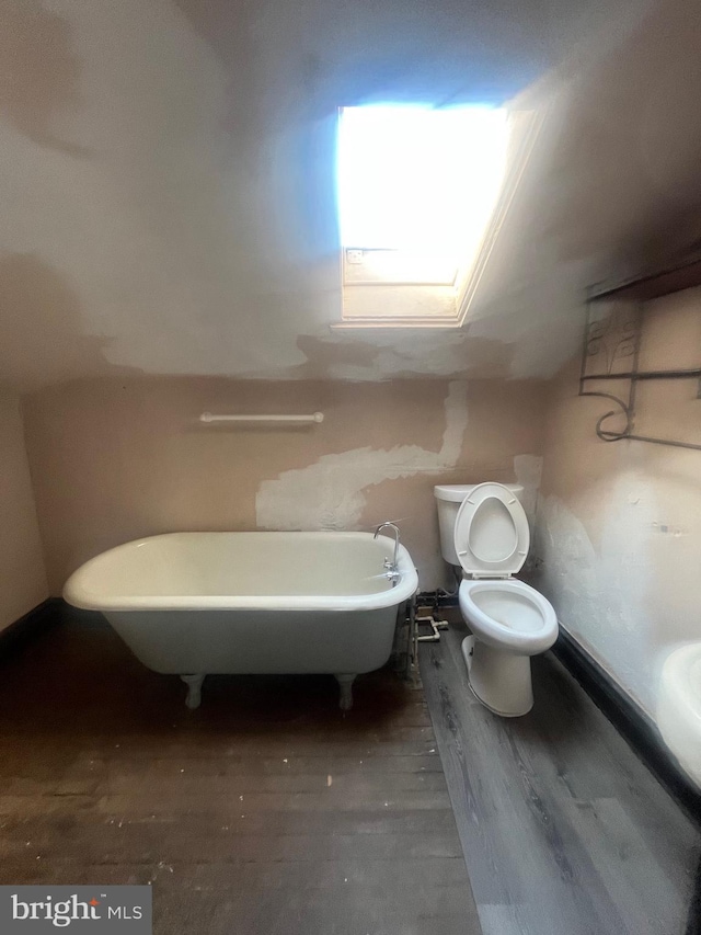 bathroom featuring toilet, a bathtub, and hardwood / wood-style floors